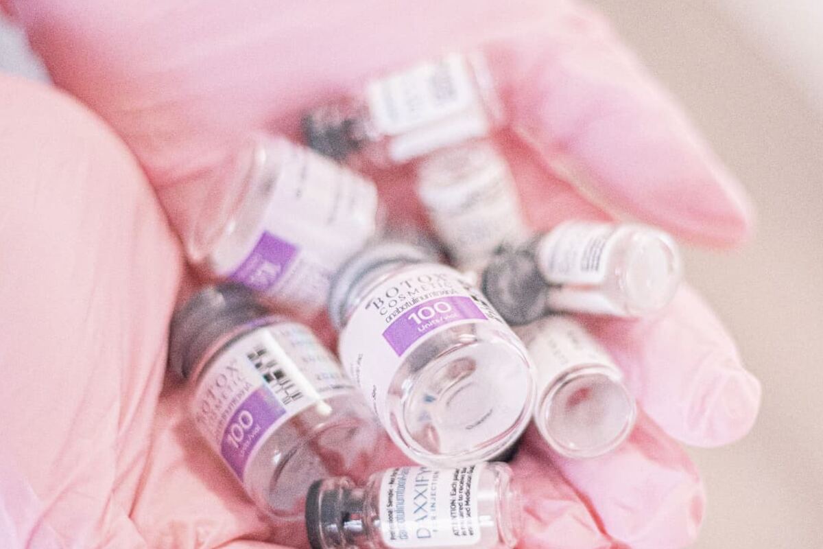 Gloved hand holding labelled vials in a formulation environment