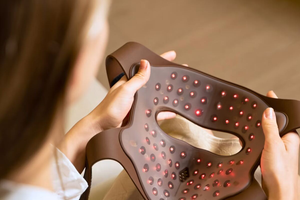 Red light therapy mask held before a session